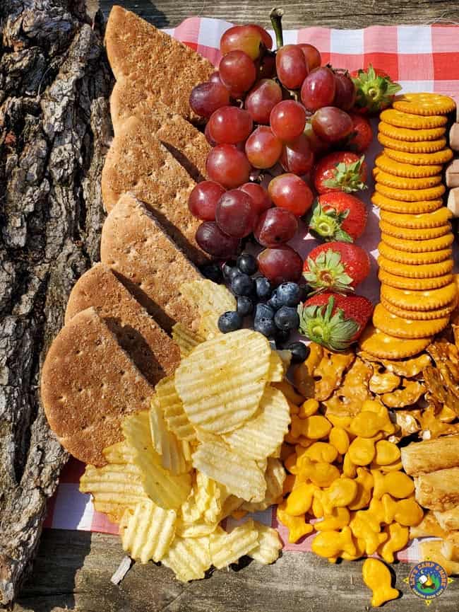Fruits, crackers, chips, and bread on a charcuterie board