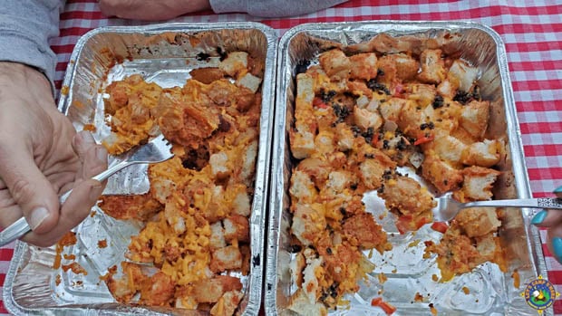 hands holding forks over 2 pans of pull apart pizza bread