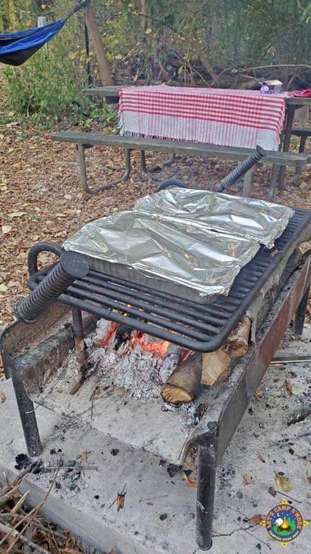 pans of campfire pizza foil pans cooking over a campfire