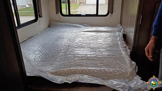 memory foam mattress from a box laid out on a bed in a camper