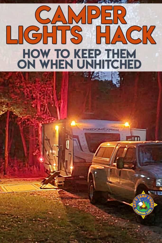 a campsite set up with a trailer with it's running lights on