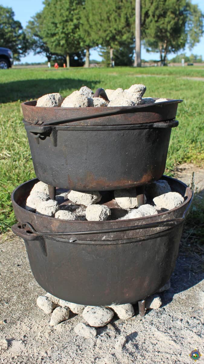 two dutch ovens stacked on top of each other with coals on them