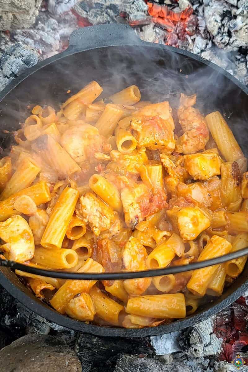 pasta and cheese added to dutch oven with the chicken