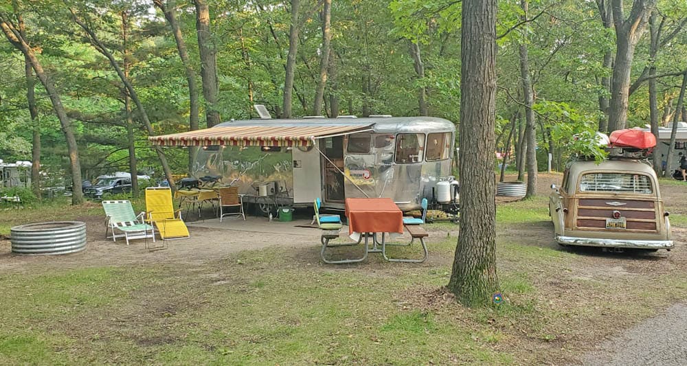 vintage camper and woody wagon in a Large Michigan State Park Campsite