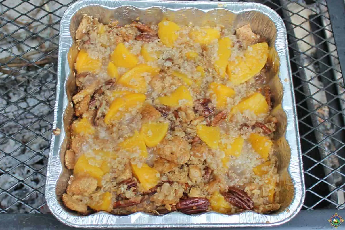 Peach Crisp in a foil pan made over a campfire