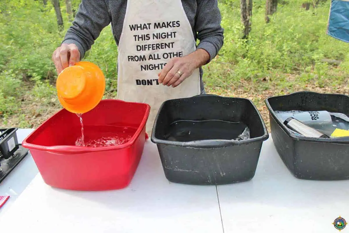 Man Washing Camping Dishes Outside