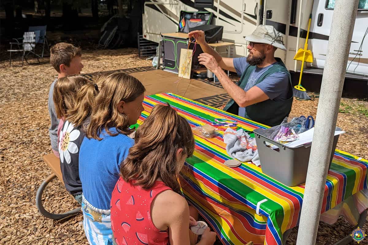 Michigan State Park Campground Host showing kids how to make a bracelet