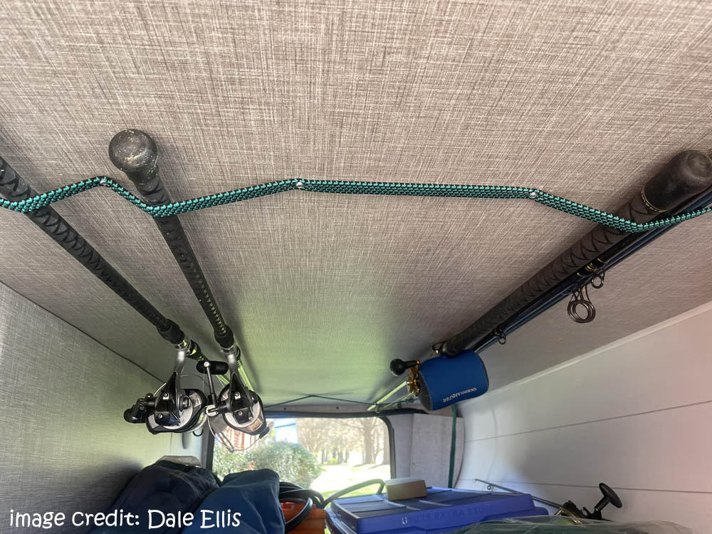 bungy cords in an RV storage compartment holding fishing poles