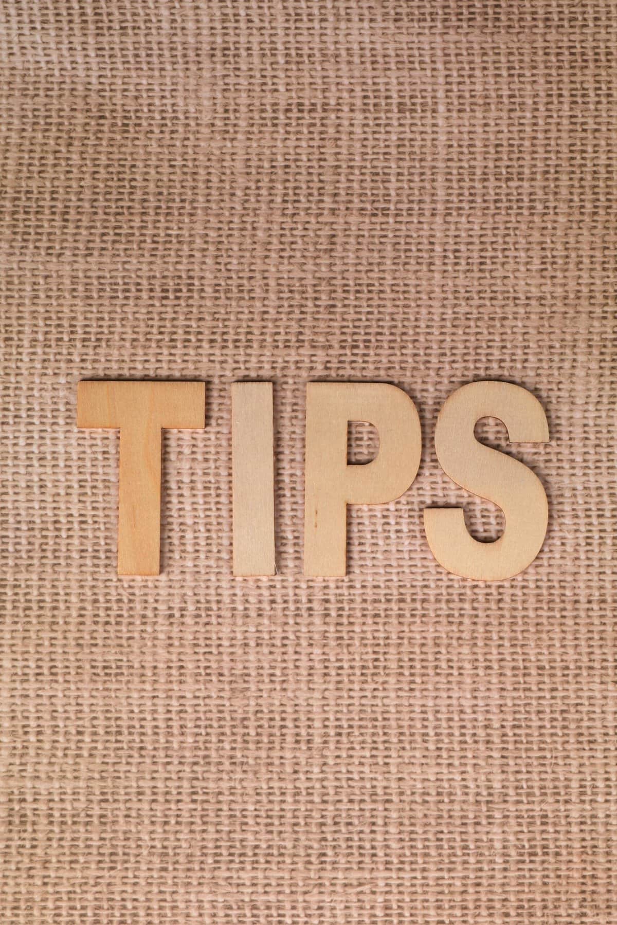 a jute background with the word 'tips' spelled out in wooden letters