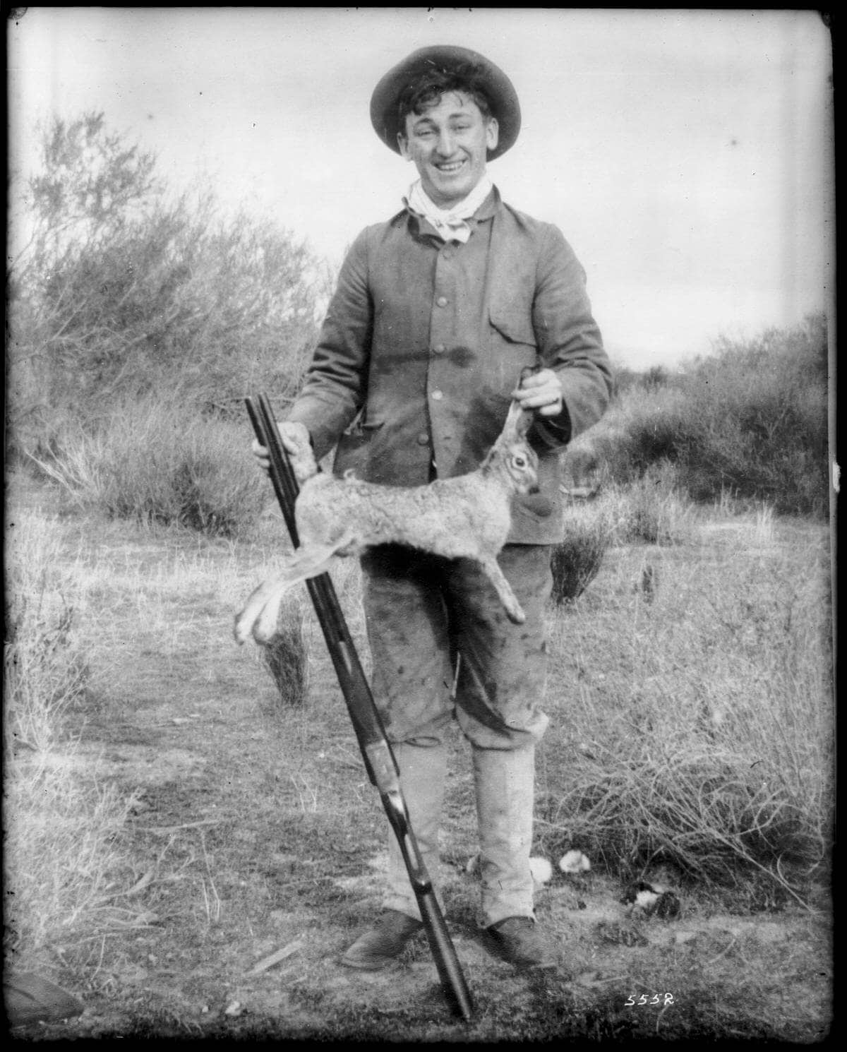 portrait of a hunter holding a dead jackrabbit by the ears and tail ca 1900 chs 5552