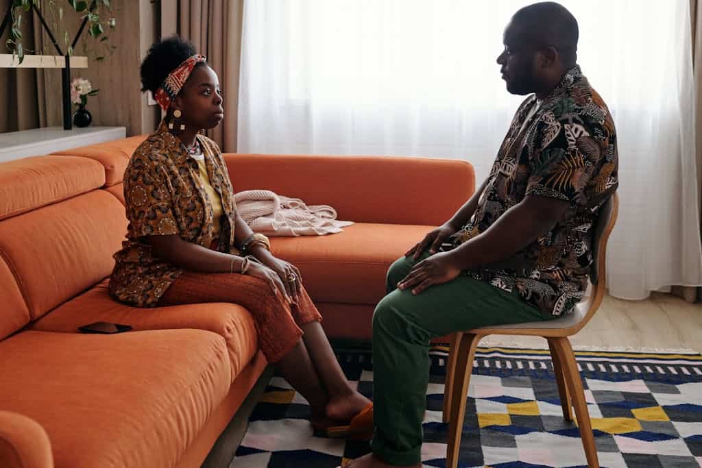A couple engaged in a thoughtful conversation at home, reflecting on possible relationship challenges.
