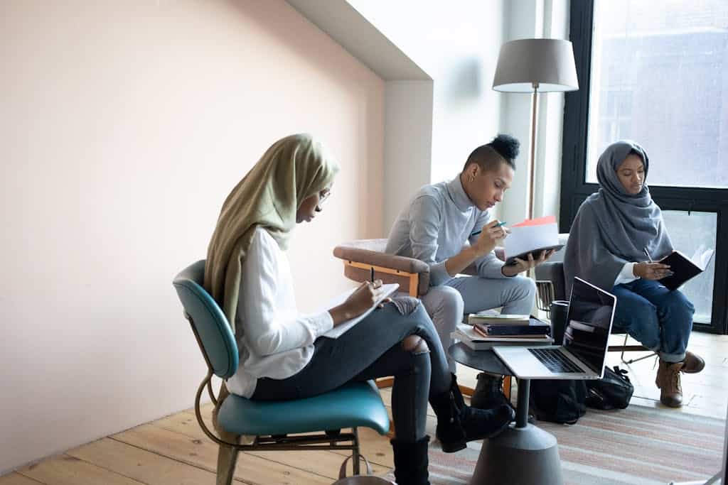 A diverse group of young adults working collaboratively in a modern office setting.