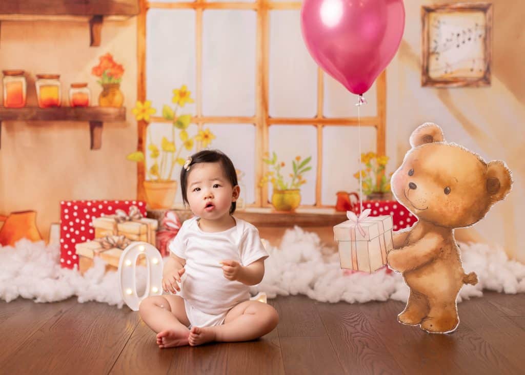 teddy bear themed cake smash for girl in Edmonton with soft browns, plush props, and a bear-shaped gift