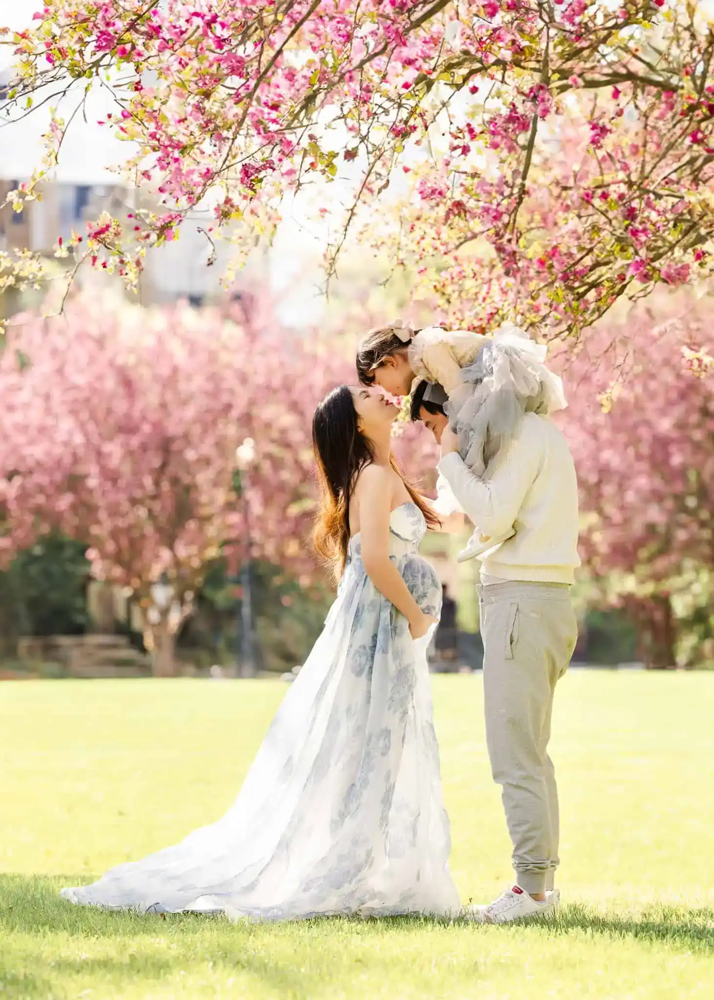 Family of three walking through a field of flowers at sunset in Edmonton