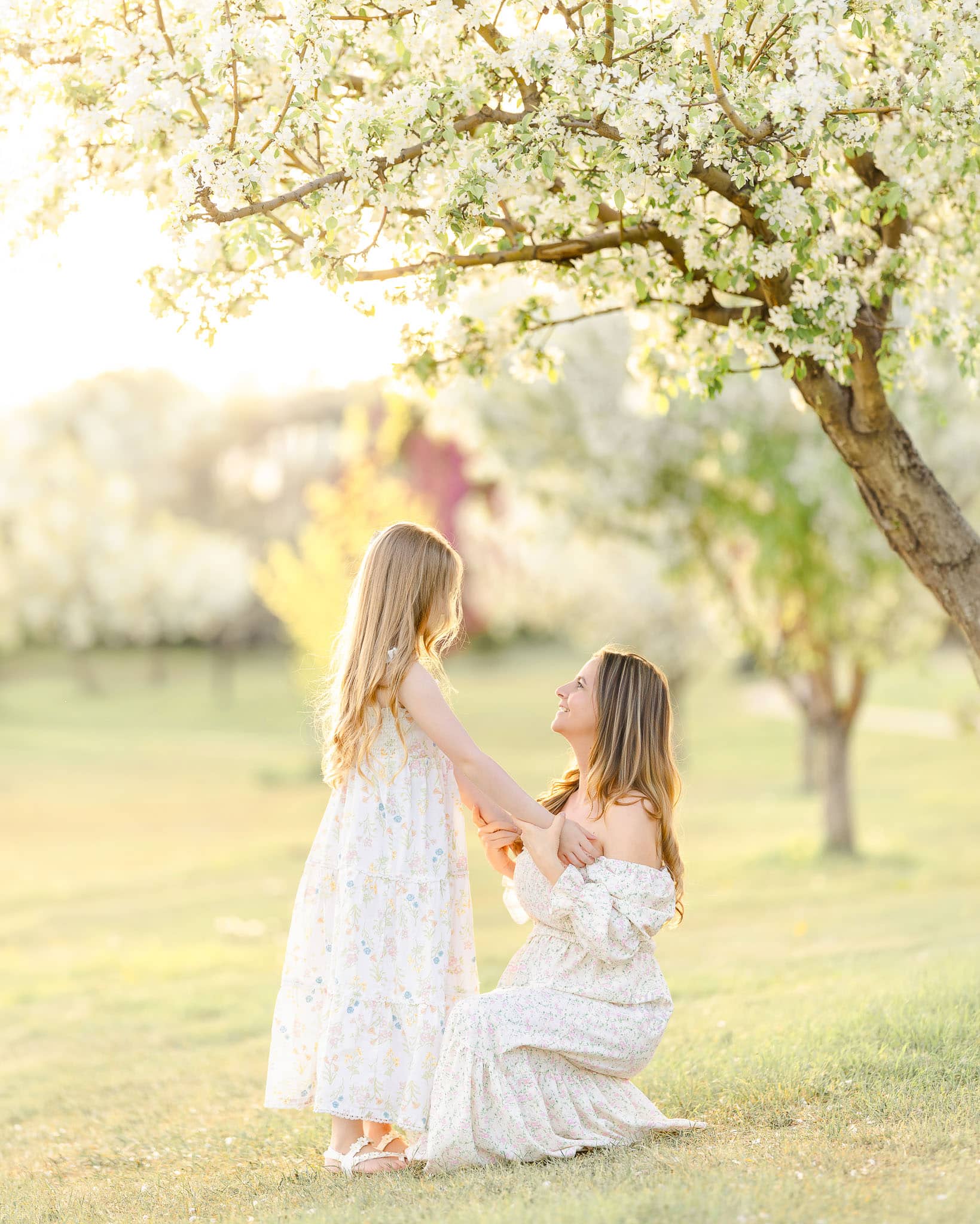 Mom hold girl's hand and softly talk to her, for a family photoshoot in Esmonton