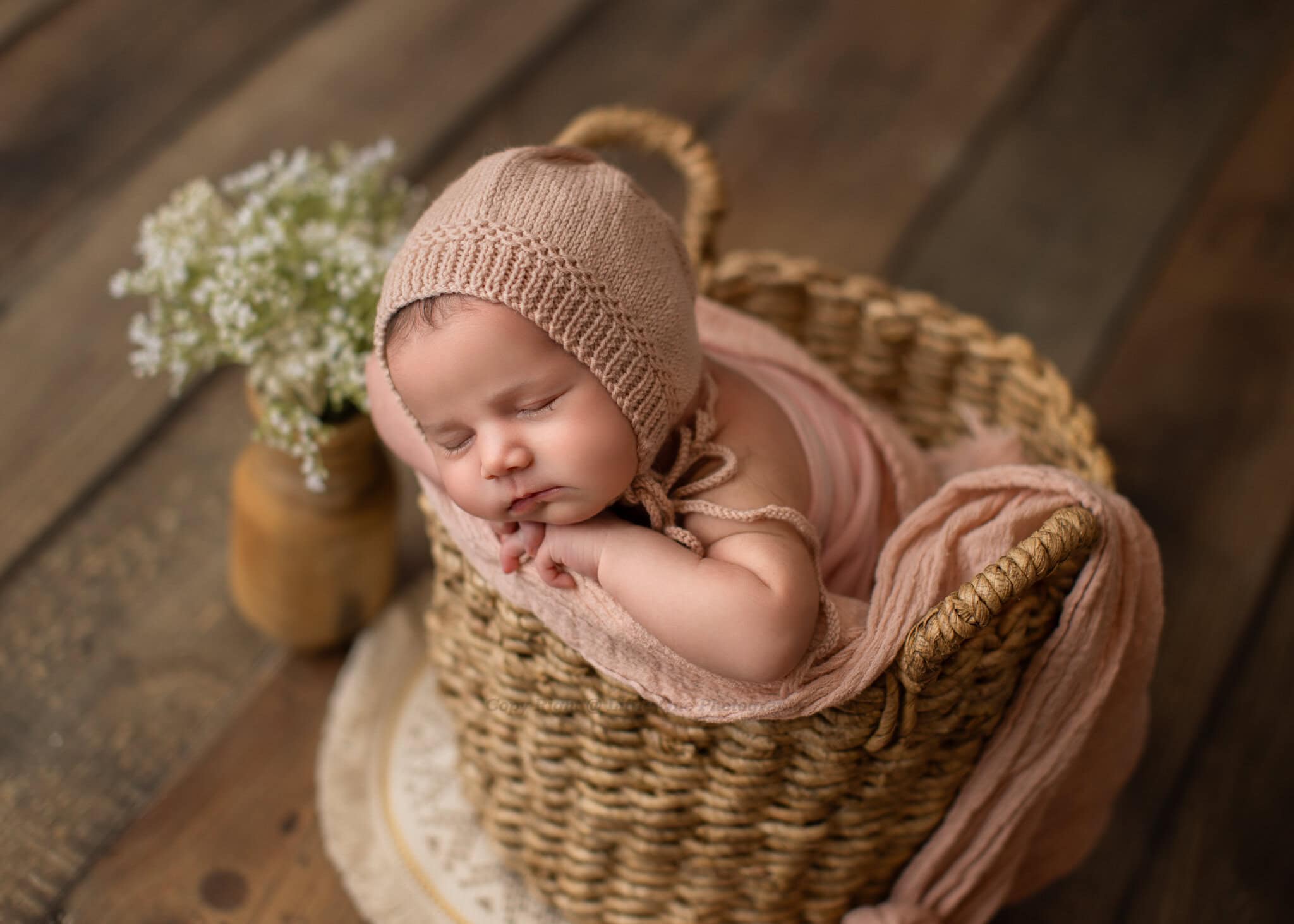 Professional newborn photography featuring a peaceful baby in a cozy studio setup