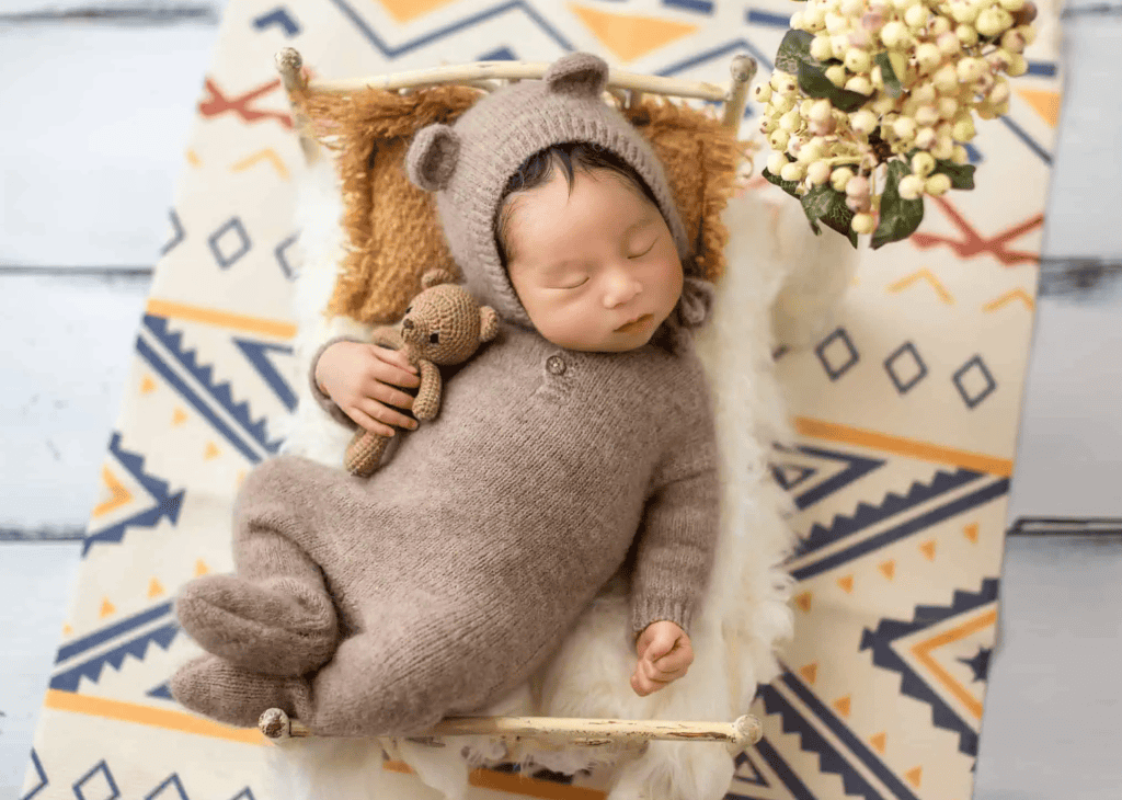 newborn baby hold teddy bear