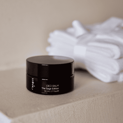 natuurlijke deodorant, de deo balm. zwart minimalistisch potje deo met witte doek op de achtergrond