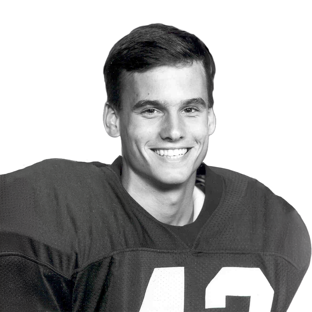Young male football player smiling in uniform, holding a football, Lou Groza Award.