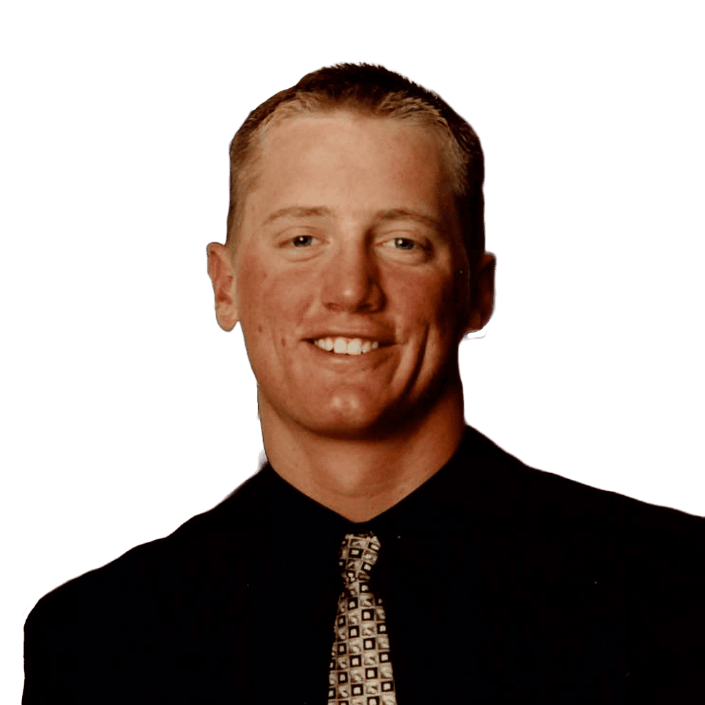 Young man smiling, wearing a black shirt and patterned tie, professional portrait.
