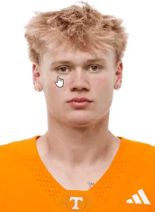 Young football player in orange uniform with Tennessee logo on jersey.