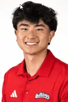 Young male football player smiling in red team jersey with Bulldogs logo.