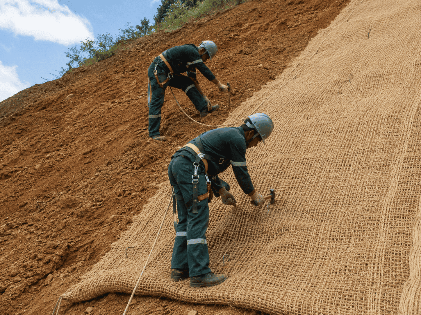 Equipe Regga instalando biomanta de fibra natural em talude