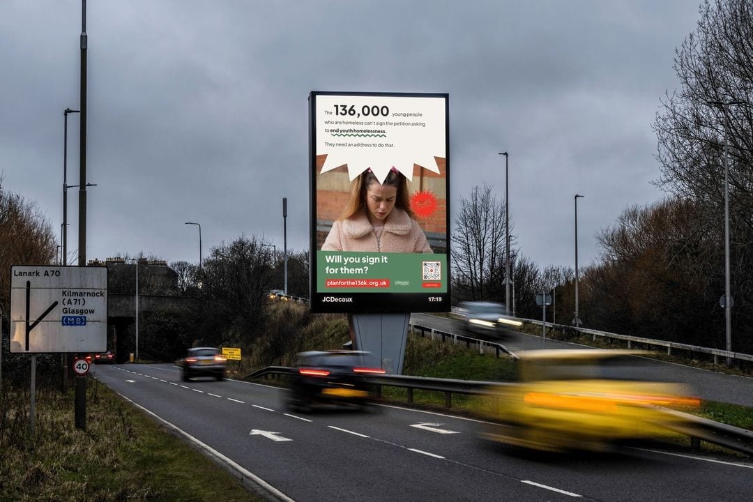 A large roadside billboard delivers a public service message about missing children. The scene includes a busy road with various vehicles, a speed limit sign, and bare trees in the background.
