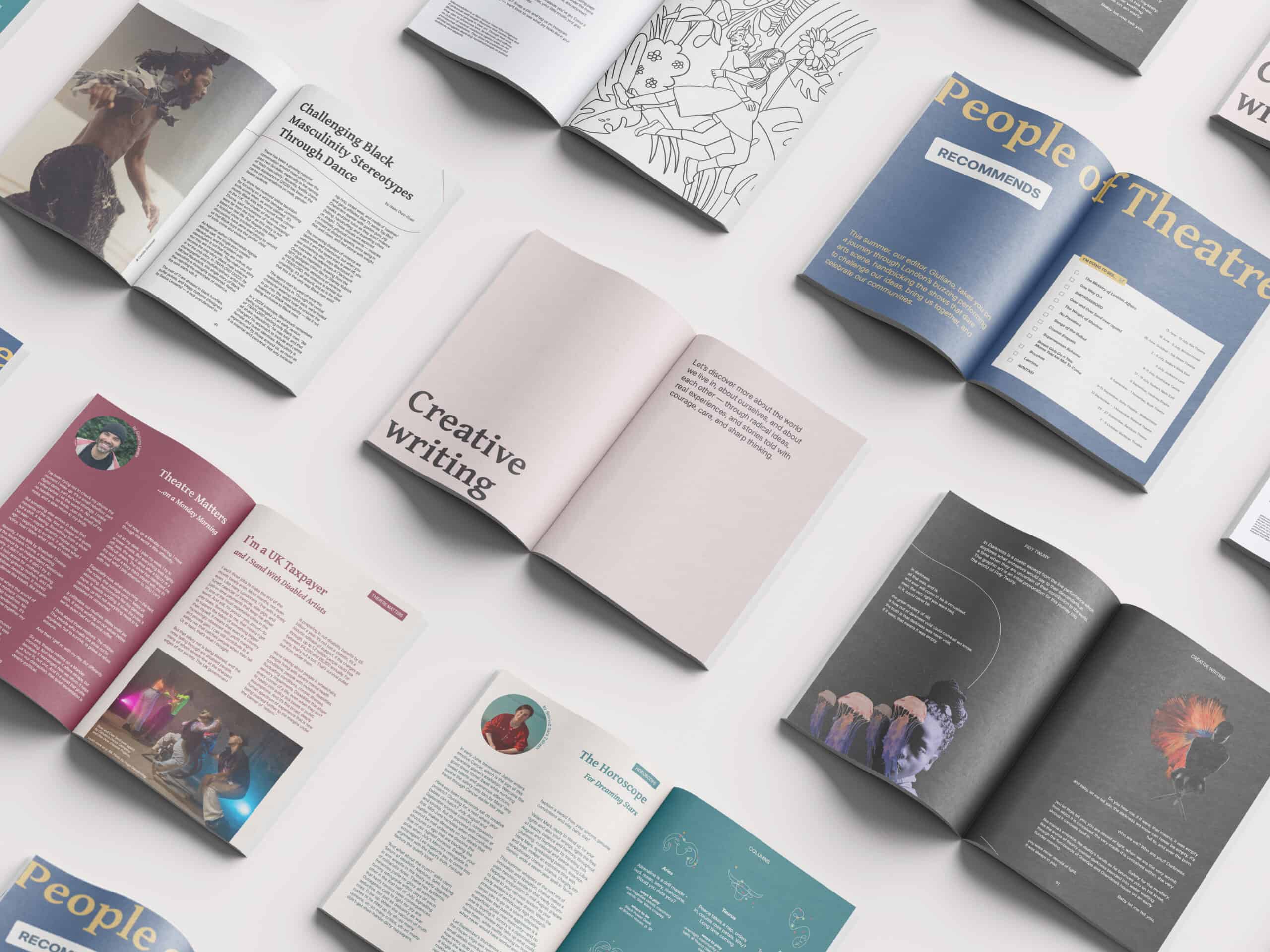 Multiple open magazines are spread on a white table, showing colourful layouts with articles, photos, theatre interviews, illustrated pages, and creative writing from diverse contributors.