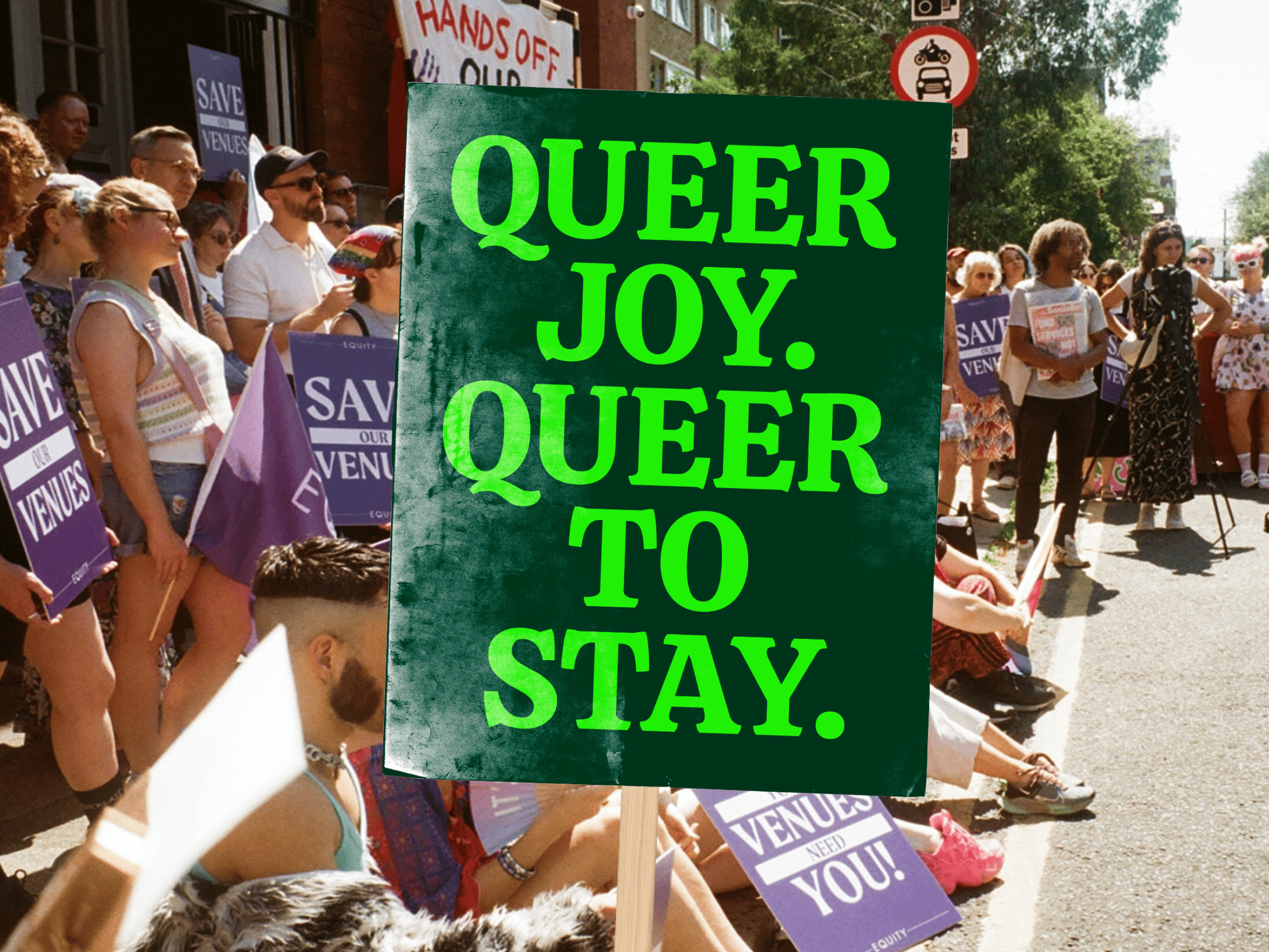 Crowd at a street protest holding signs; front sign says “QUEER JOY. QUEER TO STAY.” Others hold “SAVE OUR VENUES” posters.