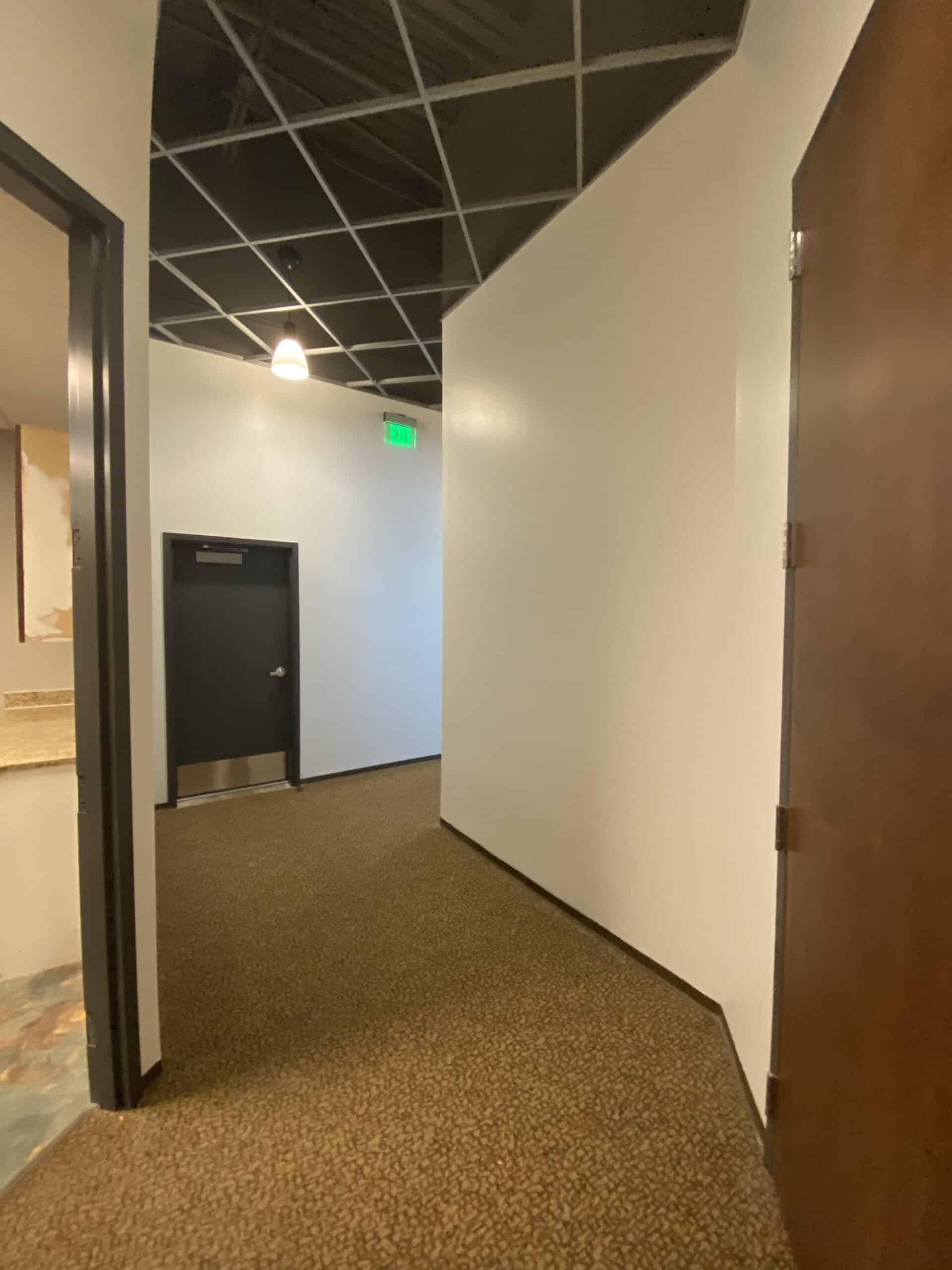 Open office hallway with glass partition walls and commercial carpet flooring - Dunwoody office build-out
