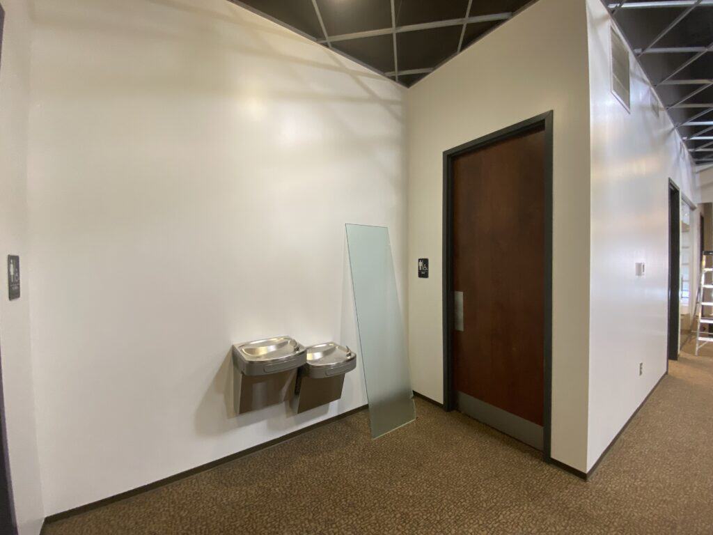 Commercial restroom with granite countertop, dual sinks, and tile work - Kemco office build-out Dunwoody
