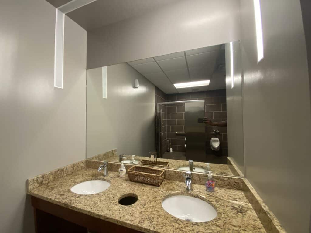 Commercial restroom with metal toilet partitions and tile walls - office build-out contractor Dunwoody GA