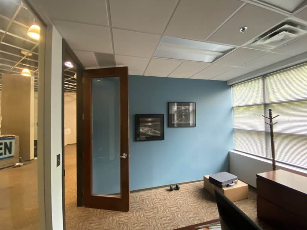 Private office with dark wood desk and commercial carpet flooring - office build-out contractor Dunwoody GA