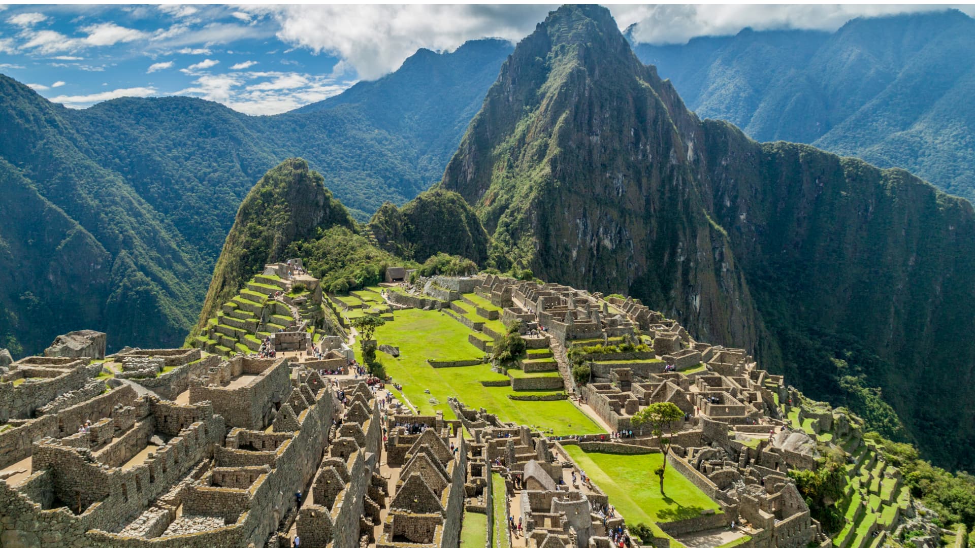 Scenic view of Machu Picchu with lush green terraces and ancient Inca ruins – Cusco to Machu Picchu, Cusco Magical Travel Agency