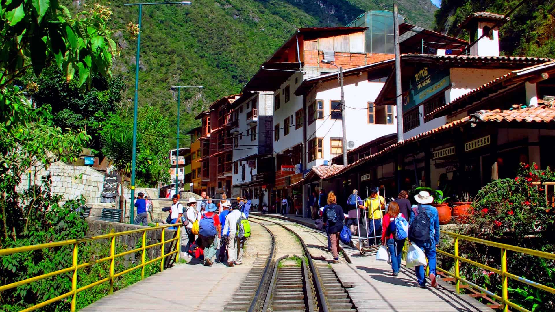 Tourists walking along the railway tracks in Aguas Calientes, the gateway to Machu Picchu – Cusco to Machu Picchu, Cusco Magical Travel Agency