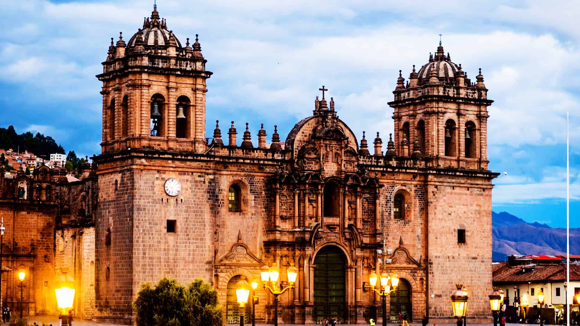 The majestic facade of the Cusco Cathedral illuminated by streetlights at dusk