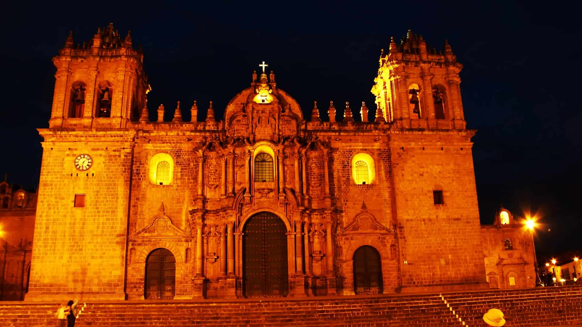 Illuminated facade of the Cusco Cathedral at night, showcasing its colonial architecture.