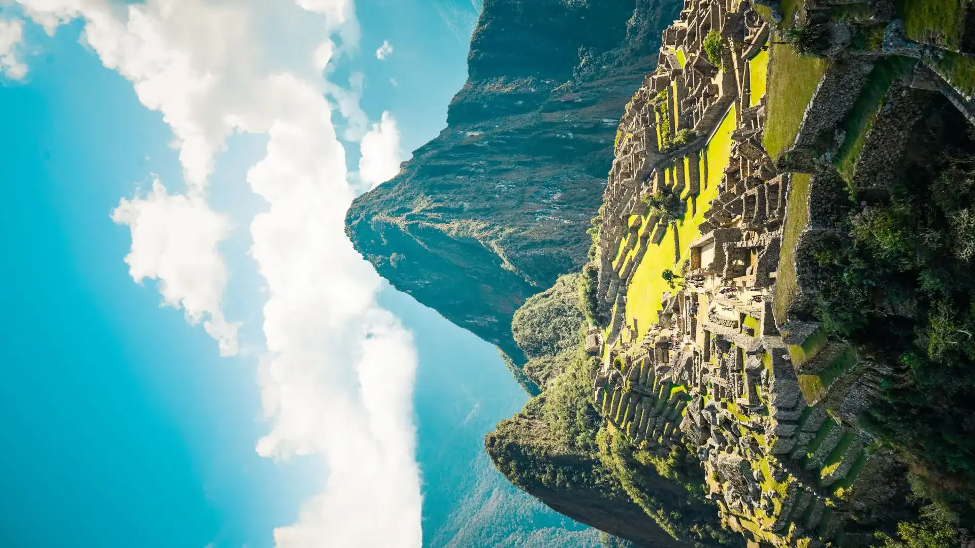 Ancient Machu Picchu ruins with terraced fields and stone structures in the Peruvian Andes.