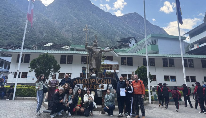 Tour group at Machu Picchu Pueblo with scenic mountain backdrop.