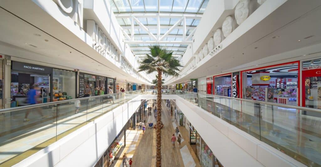Facade af Indkøbscenter Miramar i Fuengirola med moderne arkitektur og palmer