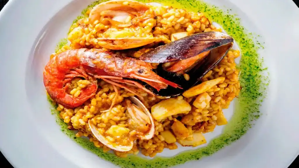 Kok tilbereder autentisk paella over åben ild i Spanien
