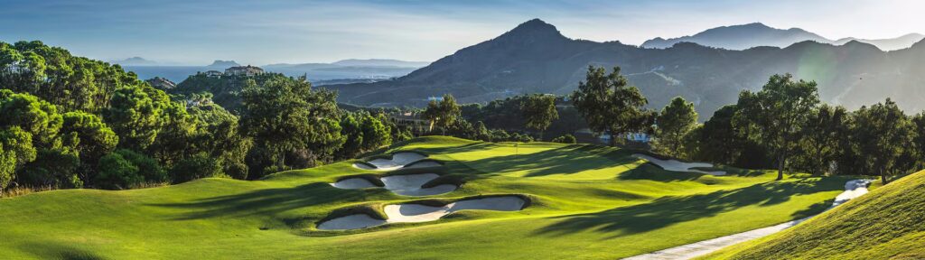 Udsigt over en grøn golfbane på Costa del Sol med Middelhavet i baggrunden