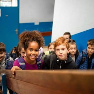 Happy primary school children with backpacks at Mangorei School in New Zealand.
