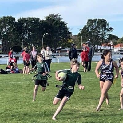 Mangorei School sports day with kids running and playing rugby on the school field during afternoon.