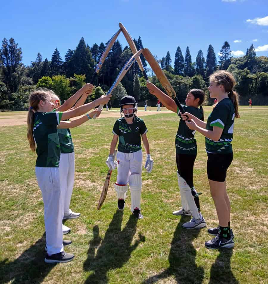 Kids playing cricket at Mangorei School sports field, fostering teamwork and outdoor activity.