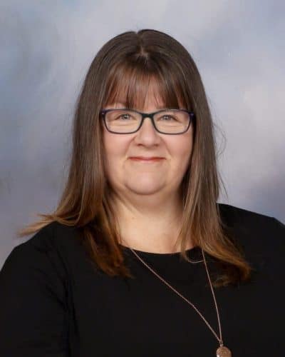 Professional woman at Mangorei School, New Zealand, staff member portrait in black attire and glasses, smiling for the school website.