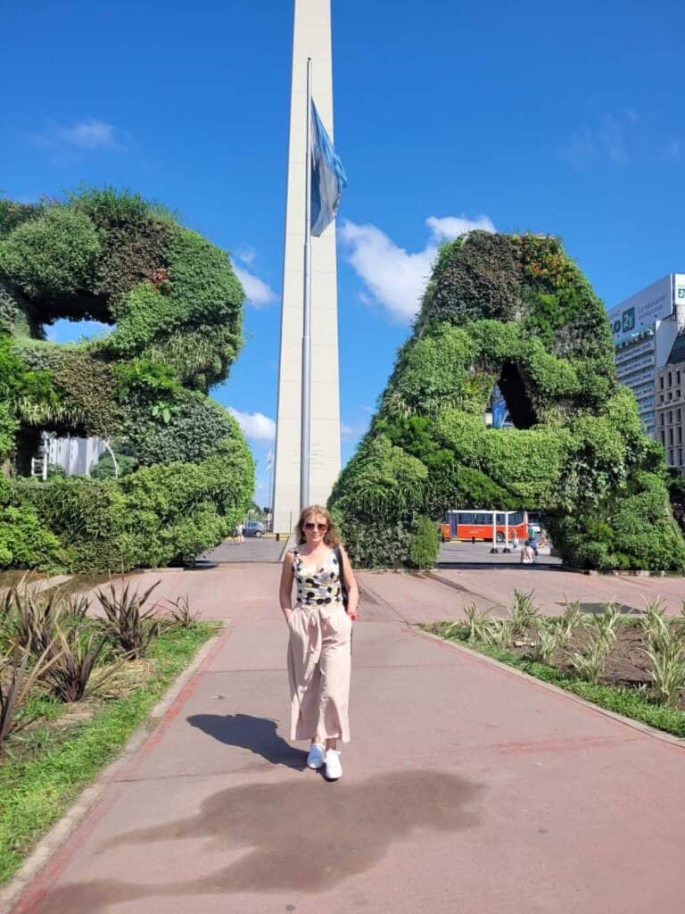 Maria of Map And Camera in front of the Obelisk of Buenos Aires. Taking a picture with the big BA letters at The Obelisk is one of the most touristy thing to do in Buenos Aires