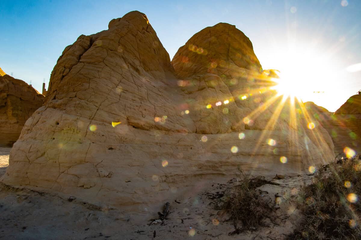 Sun peeking over rugged rock formations in the desert near Sabbia Dura, Tunisia – a stunning landscape for nature lovers and one of the most dramatic places to visit in southern Tunisia.