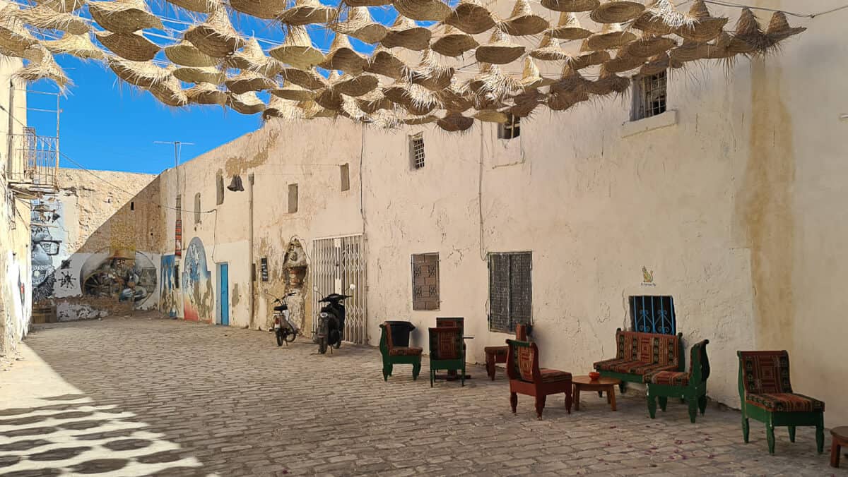 Traditional alley in Houmt Souk, Djerba Island, with colorful street furniture and overhead woven shades – one of the most atmospheric towns to visit in Tunisia for shopping and local life.